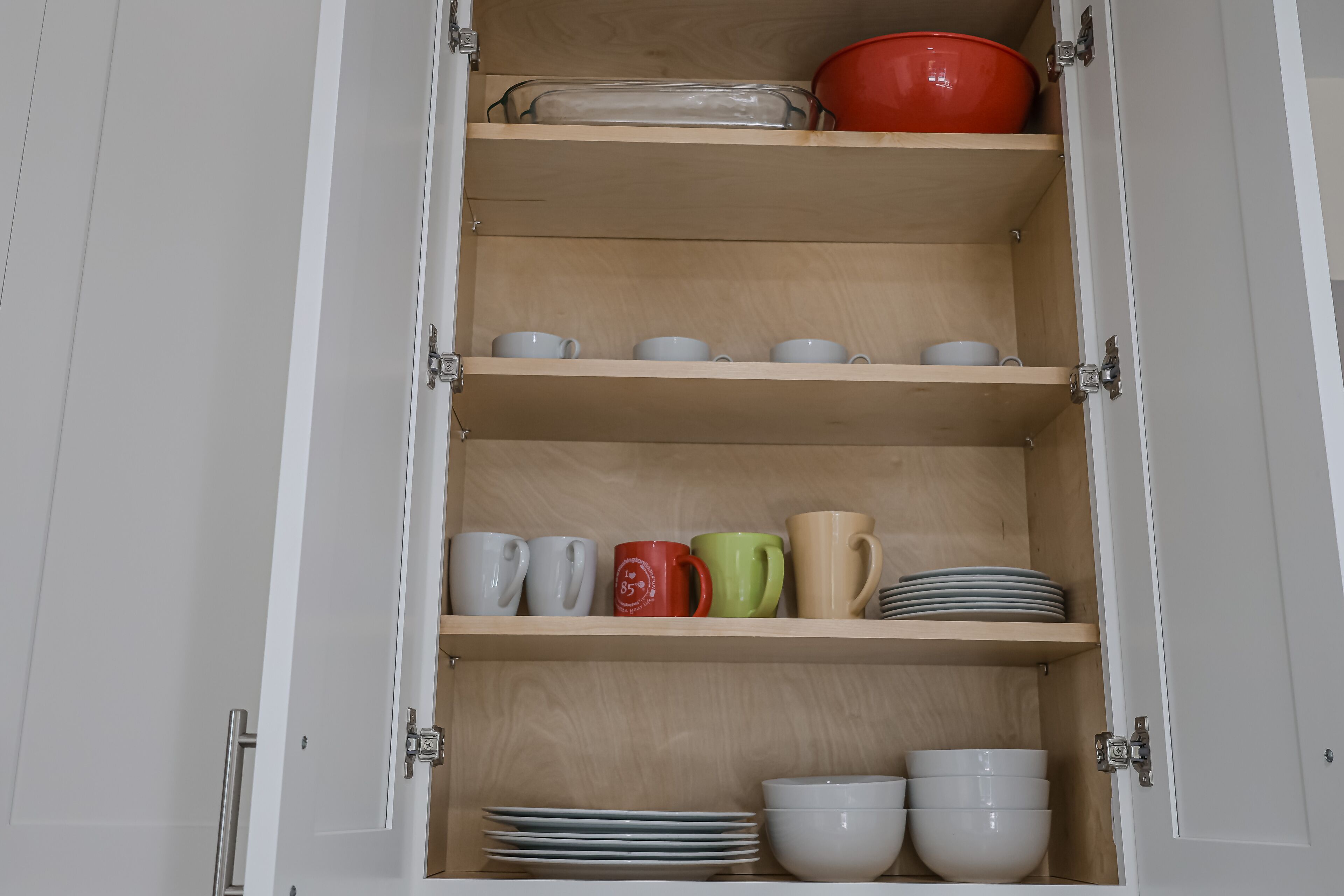 Un mueble con varios estantes que contiene platos y tazas.