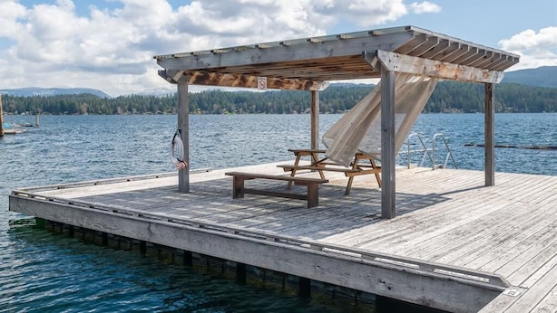 A wooden dock with a covered seating area and a picnic table. - The Spot on Sproat Lake (Port Alberni)