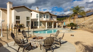 Una casa con piscina, mobiliario exterior y zona de patio.