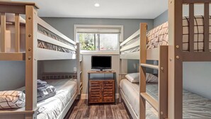 A bunk bed room with a TV, wooden furniture, and a window. - Stratton; 8 min! Fire Pit. BBQ. Pet friendly (Winhall)