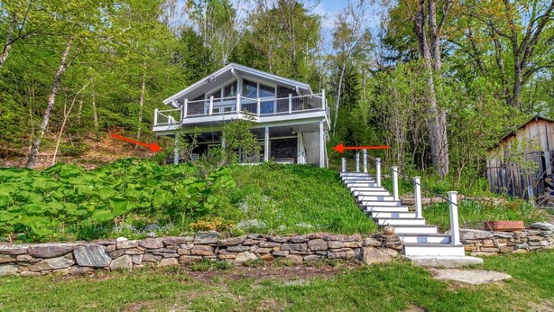 A two-story house with a stone retaining wall and a staircase leading to the entrance. - Stratton; 8 min! Fire Pit. BBQ. Pet friendly (Winhall)