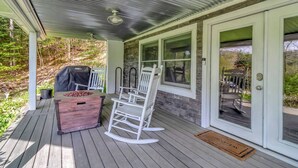 A covered porch with a grill, rocking chairs, and a wooden bench. - Stratton; 8 min! Fire Pit. BBQ. Pet friendly (Winhall)