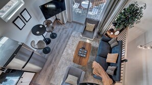 A modern living room with a sofa, chairs, a coffee table, and a TV. - Modern Paradise Getaway: Hot Tub, Mini Golf, Fire Pit, Dog Friendly, Parking (Colorado Springs)