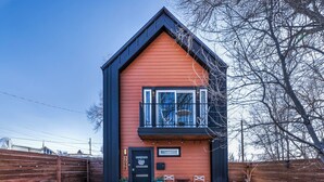 A modern two-story building with a red facade and black trim. - Modern Paradise Getaway: Hot Tub, Mini Golf, Fire Pit, Dog Friendly, Parking (Colorado Springs)