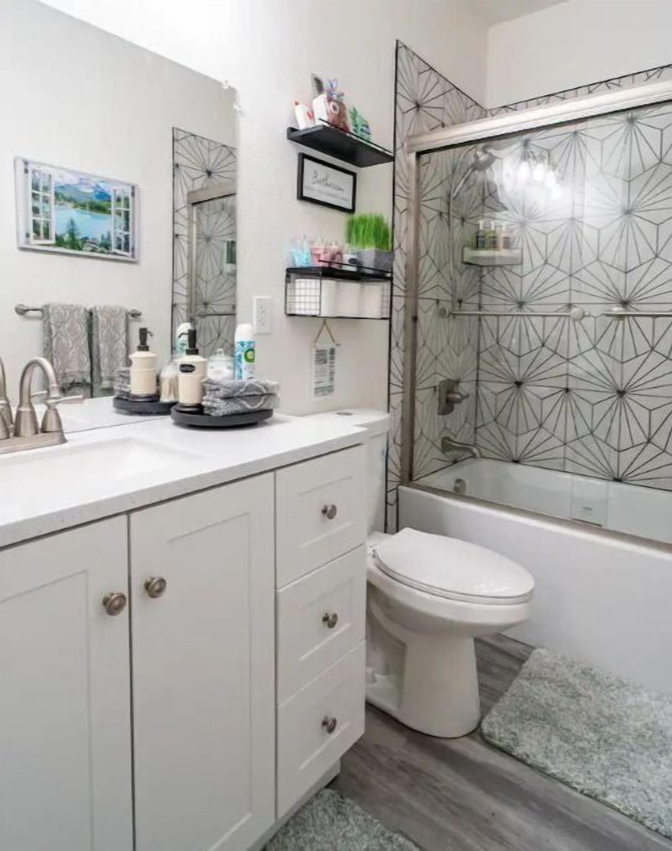 Un baño moderno con tocador blanco, inodoro y zona de ducha.