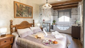 A bedroom with a wooden bed, a swan decoration, a tray with breakfast, and a bathroom with a bathtub.