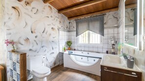 Une salle de bain équipée d’une baignoire, de toilettes et d’un meuble-lavabo avec un miroir.