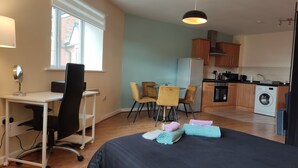 Ein kleines Schlafzimmer mit Bett, Nachttisch und Schreibtisch mit Stuhl.