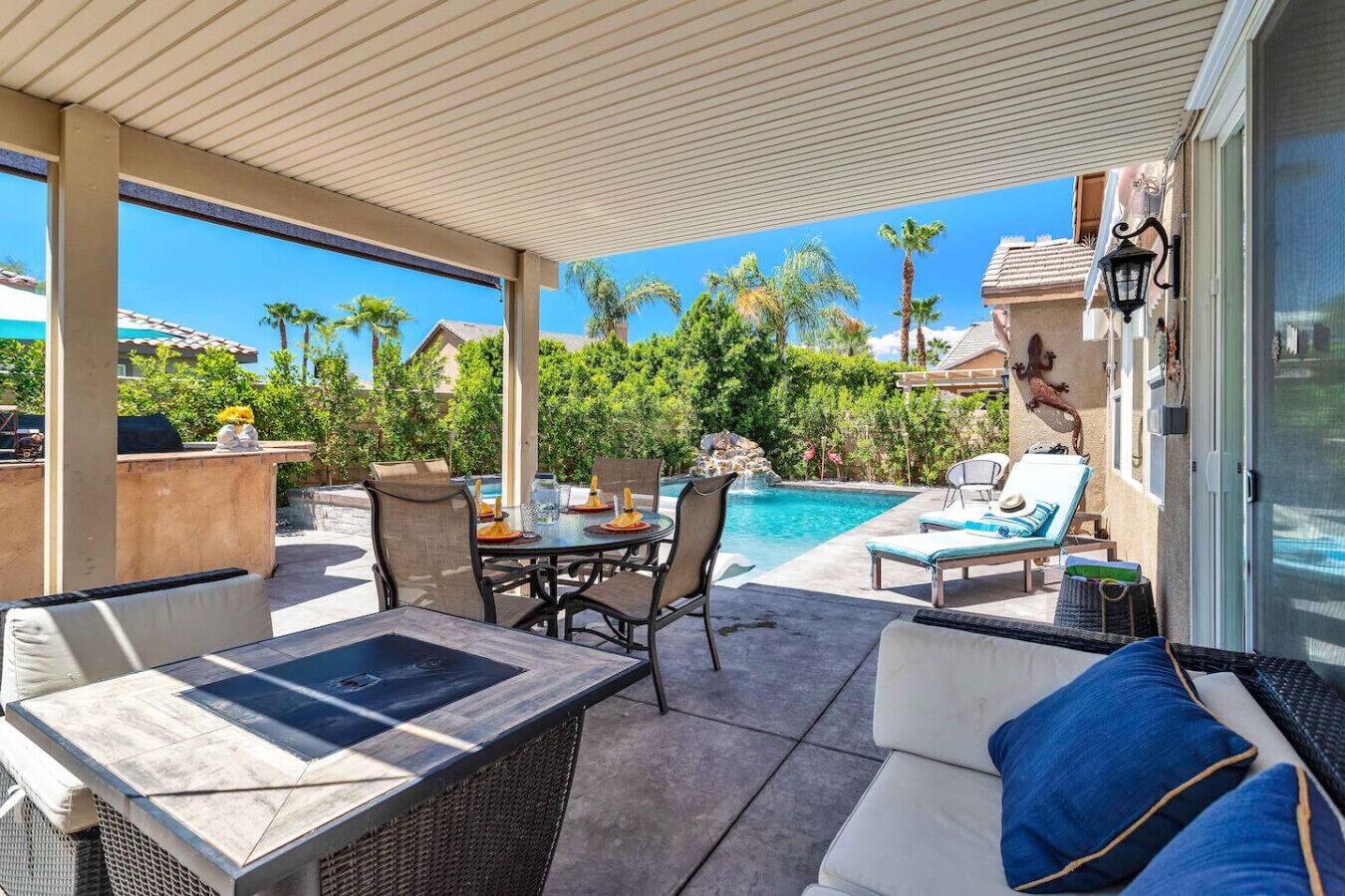Un espacio al aire libre cubierto con piscina, sillas de descanso y una mesa de comedor.