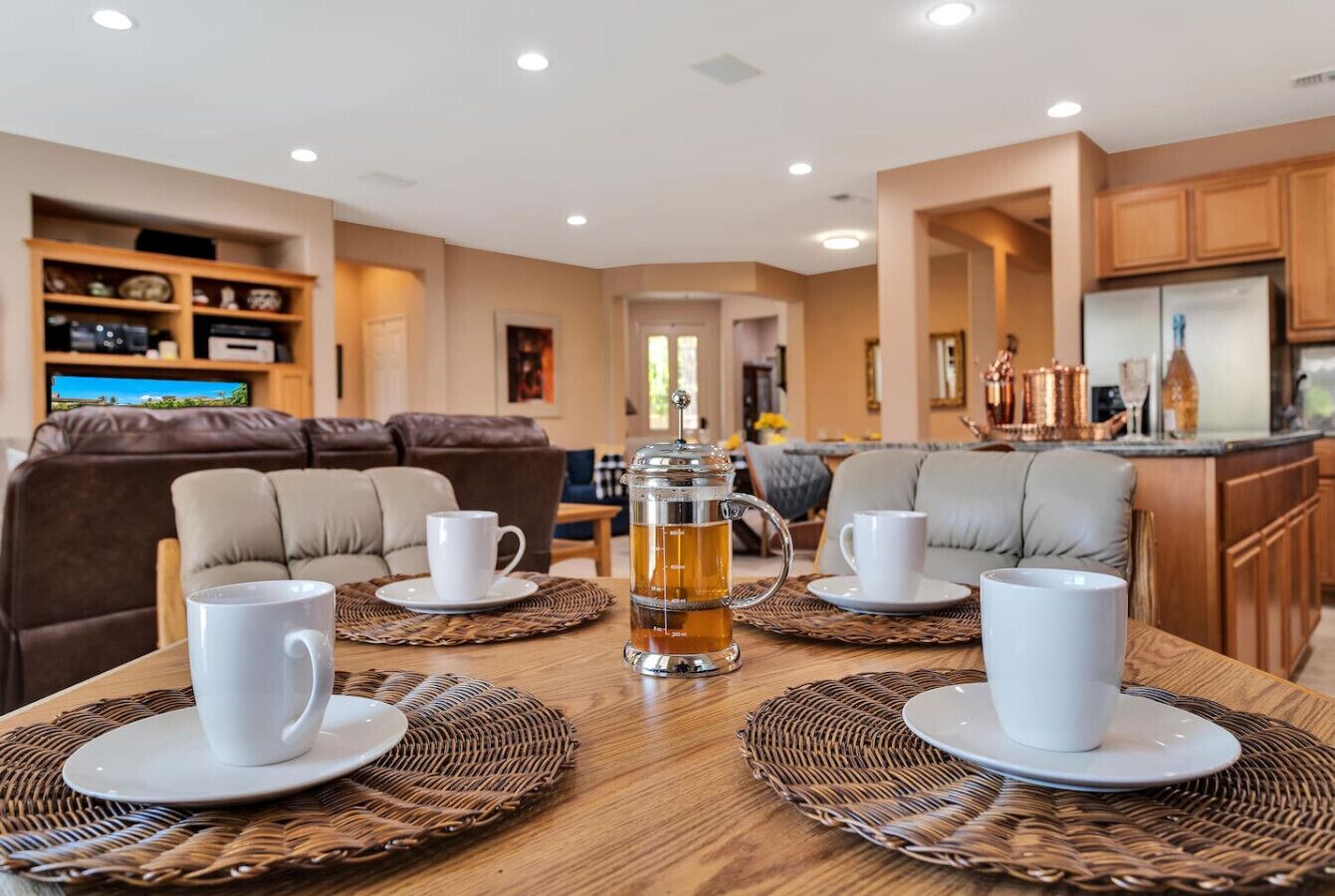 Un comedor acogedor con una mesa de madera dispuesta para cuatro personas, rodeado de asientos acolchados.