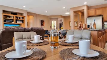 Un comedor acogedor con una mesa de madera dispuesta para cuatro personas, rodeado de asientos acolchados.