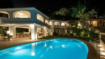 Vista frontal de la propiedad por la tarde o noche