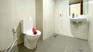 A modern bathroom with a toilet, bidet, and sink. - Great Choice Studio Apartment LRT City Jatibening (Bekasi)