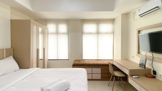 Une chambre d’hôtel avec un lit, un bureau, une chaise et un téléviseur.