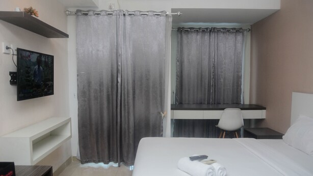 A hotel room with a bed, a desk, and a chair.