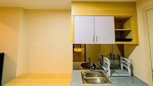 Cocina pequeña con dos fregaderos, un escurreplatos y armarios de madera.