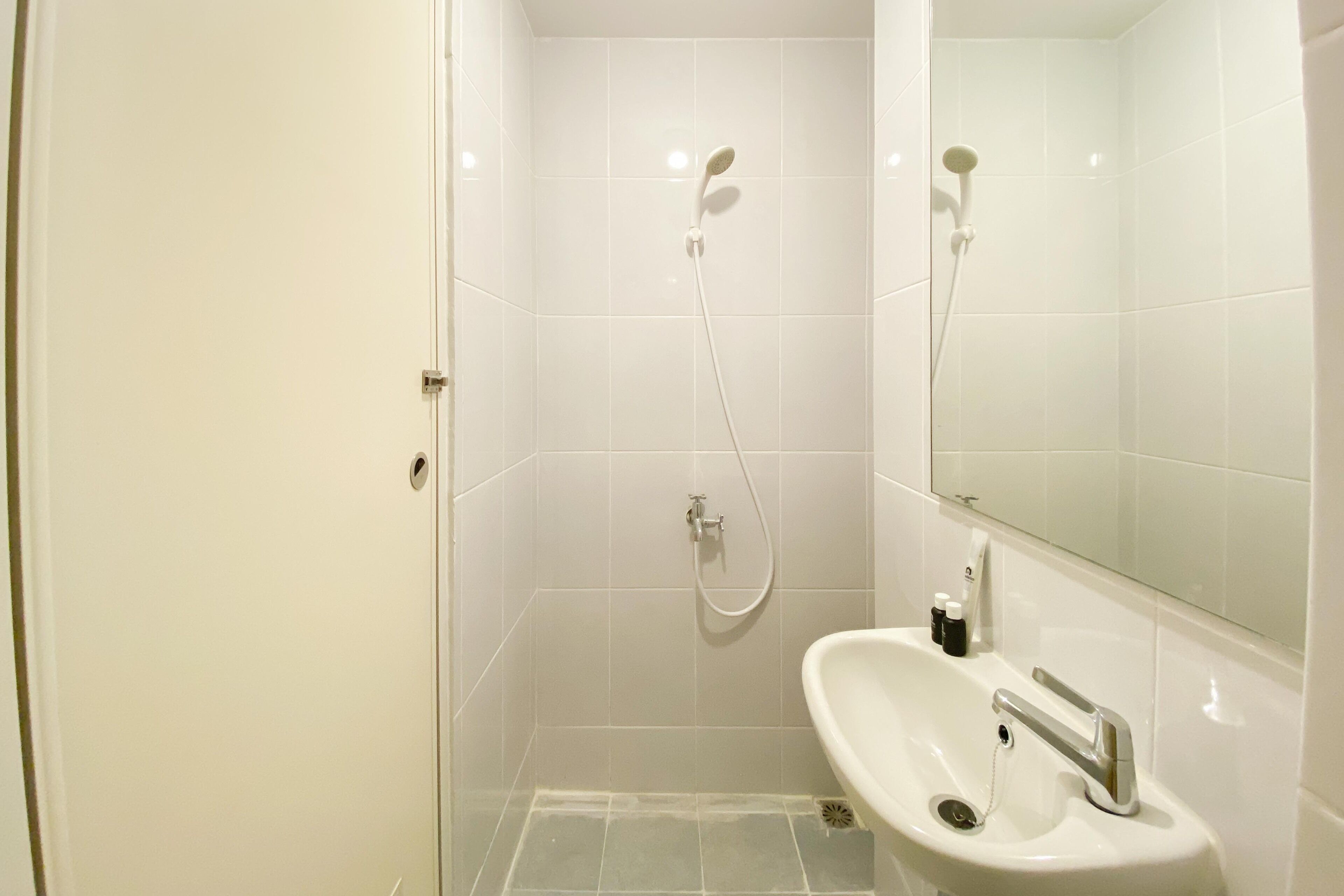 Ein modernes Badezimmer mit Dusche, Waschbecken und Spiegel.