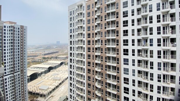 Een hoog appartementencomplex met meerdere balkons en uitzicht op de omgeving.