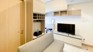 Uma sala de estar moderna com sofá, TV e estantes embutidas.