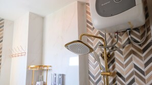 A modern bathroom with a shower, a towel rack, and a wall-mounted heater. - Spacious And Modern 3Br Apartment At Gateway Ahmad Yani Cicadas (Bandung)