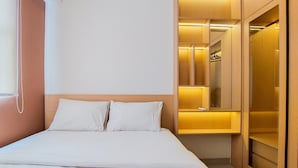 A hotel room with a bed, a wardrobe, and a mirror. - Comfortable And Warm 2Br Parkland Avenue Apartment (South Tangerang)