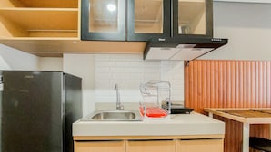 A compact kitchen with a refrigerator, sink, and a dish rack. - Comfortable And Warm 2Br Parkland Avenue Apartment (South Tangerang)