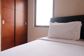 Ein Hotelzimmer mit einem Bett, einem Fenster und einem Holzschrank.