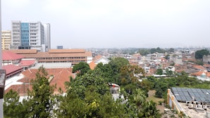 A cityscape with a mix of residential and commercial buildings, including a prominent multi-story building with a blue facade.