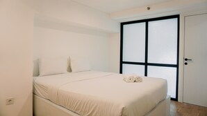 Quarto com cama, guarda-roupa e janela com vidro jateado.