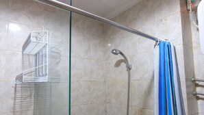 A shower area with a glass door, a metal rack, and a showerhead. - Homey 2Br At Galeri Ciumbuleuit 1 Apartment (Bandung)