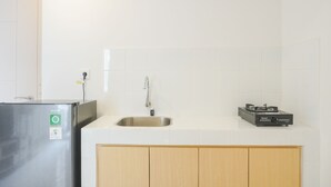 Eine Küche mit einem Edelstahl-Kühlschrank, einer Spüle und einem Herd.