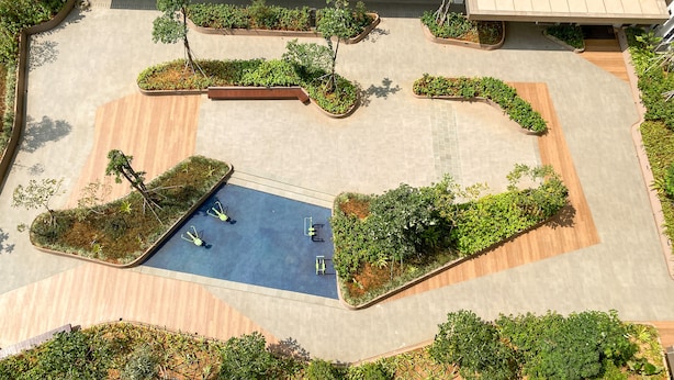 Vue aérienne d’une cour aménagée avec une piscine centrale, entourée de différents jardinières et arbres.