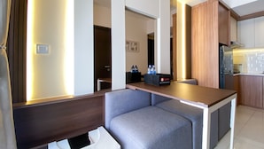 A compact kitchenette with a countertop, a small seating area with a cushioned bench, and a refrigerator. - Nice And Homey 2Br At Citra Living Apartment (Jakarta)