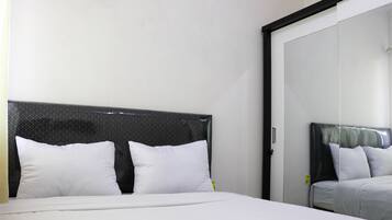 Una habitación de hotel con cama, armario y espejo.