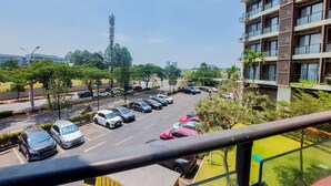 A multi-story hotel with a parking lot in front. - Comfy And Best Choice Studio At Sky House Bsd Apartment (Pagedangan)