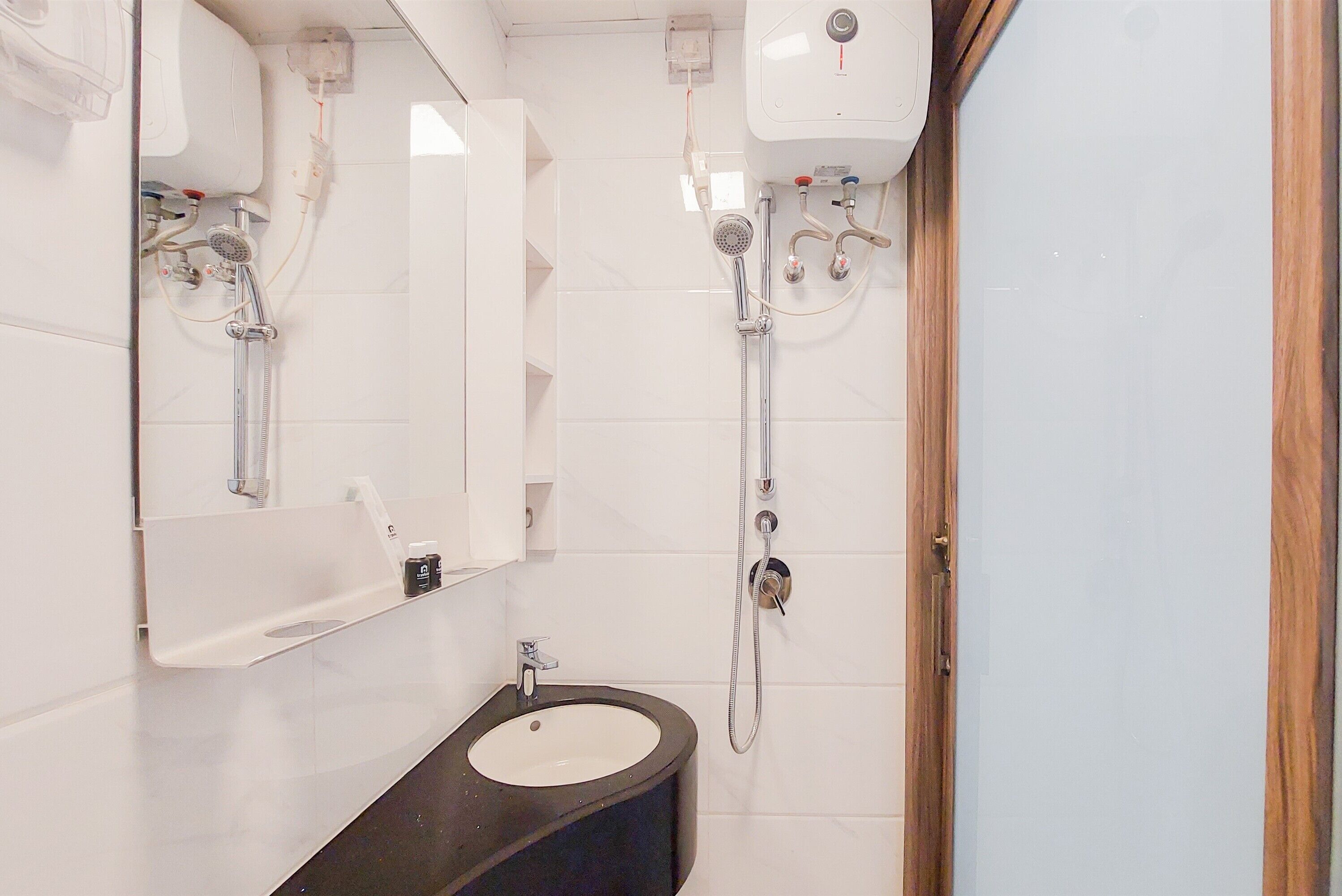 Een badkamer met een wastafel, spiegel en douche.