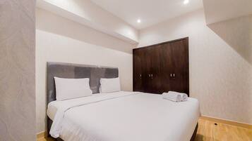 Un dormitorio con una cama grande, un armario y una lámpara en el techo.