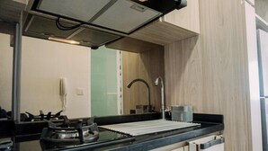 A modern kitchen with a gas stove, a sink, and a stainless steel faucet.