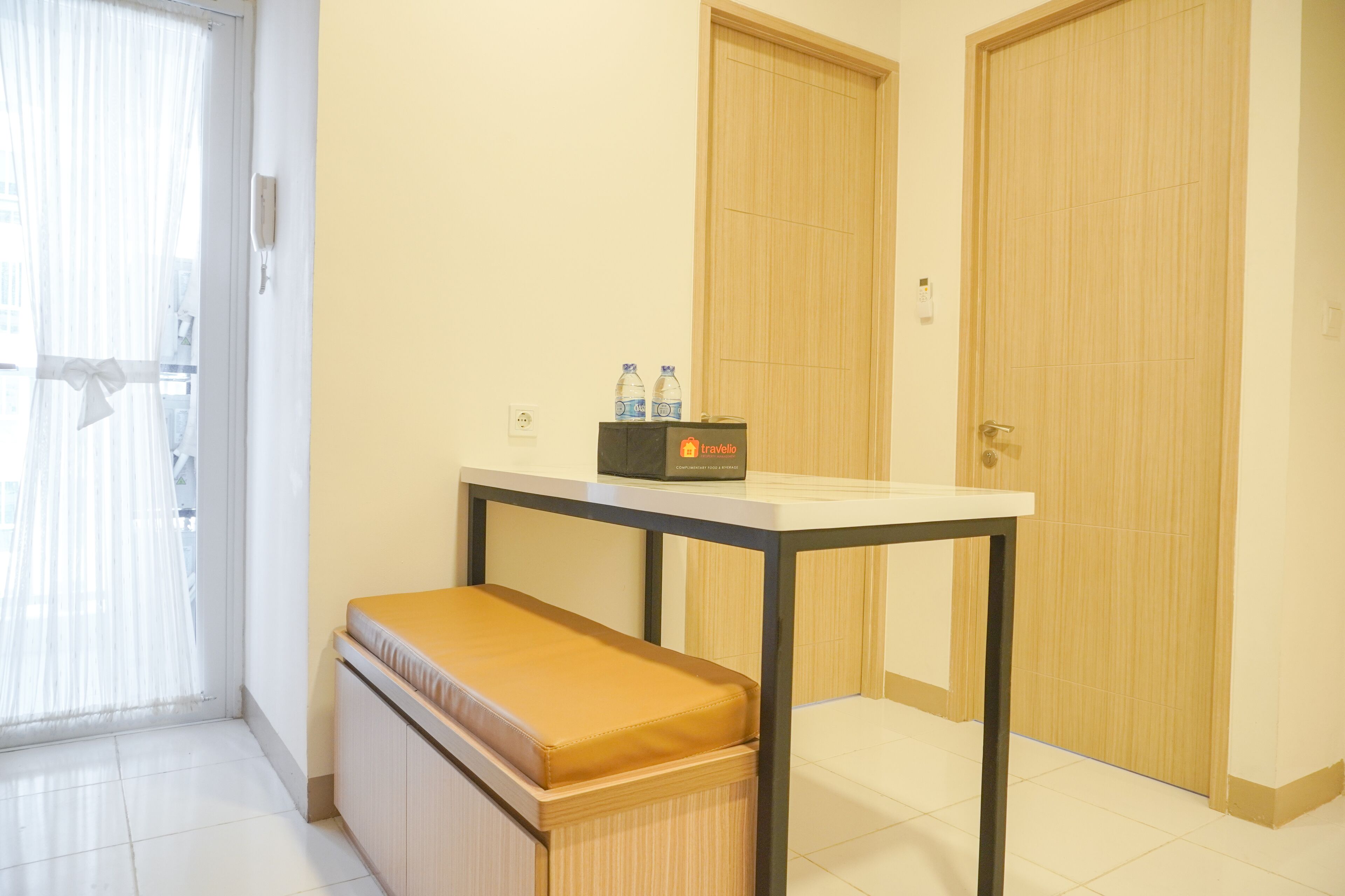 A small room with a bench, a table, and two doors.
