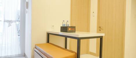 A small room with a bench, a table, and two doors.