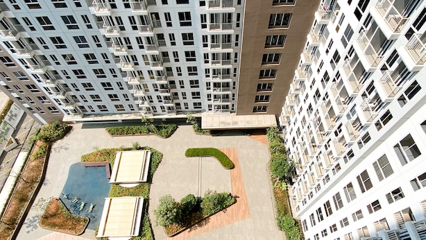 A high-rise residential building with multiple balconies, a rooftop garden, and a swimming pool area. - Good Choice And Nice Studio At Tokyo Riverside Pik 2 Apartment (Teluknaga)