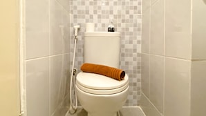 Ein Badezimmer mit Toilette, Dusche und Fliesen.