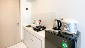 Et lille køkken med et køleskab, elkedel og kaffemaskine.