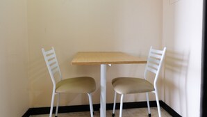 A corner room with a small table and two chairs. - Strategic And Comfy 1Br At Braga City Walk Apartment (Bandung)