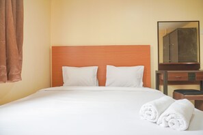Restful retreat with a neatly made bed, wooden headboard, and convenient nightstand.