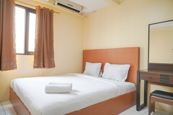 Cozy retreat with a single bed, nightstand, and mirror, perfect for a relaxing stay.