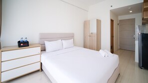 Relax in a serene space with a large bed, nightstand, and wardrobe.