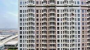 Un immeuble résidentiel de grande hauteur, doté de nombreux balcons et d’une piscine située au premier plan.
