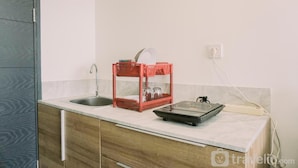 Een keuken met een spoelbak, een rode afdruiprek en een weegschaal op het aanrecht.