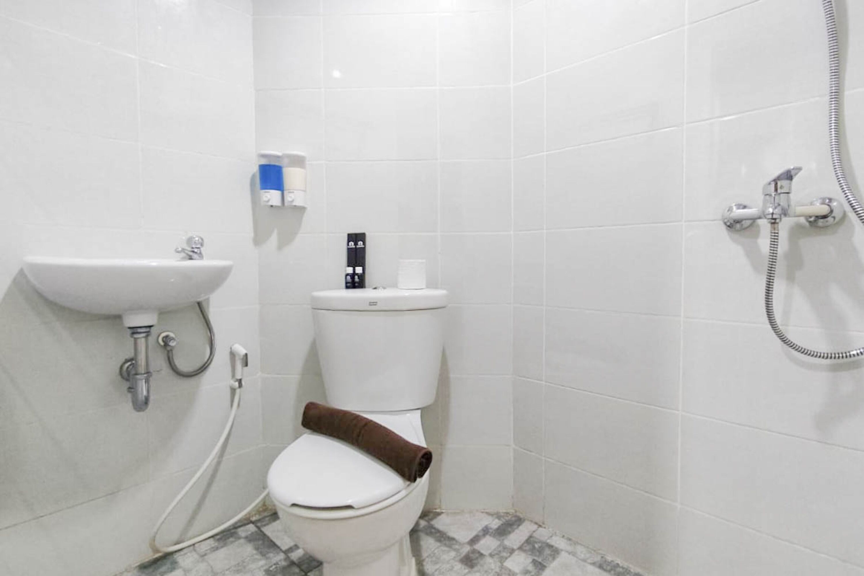 Ein kleines, sauberes Badezimmer mit Waschbecken, Toilette und Dusche.